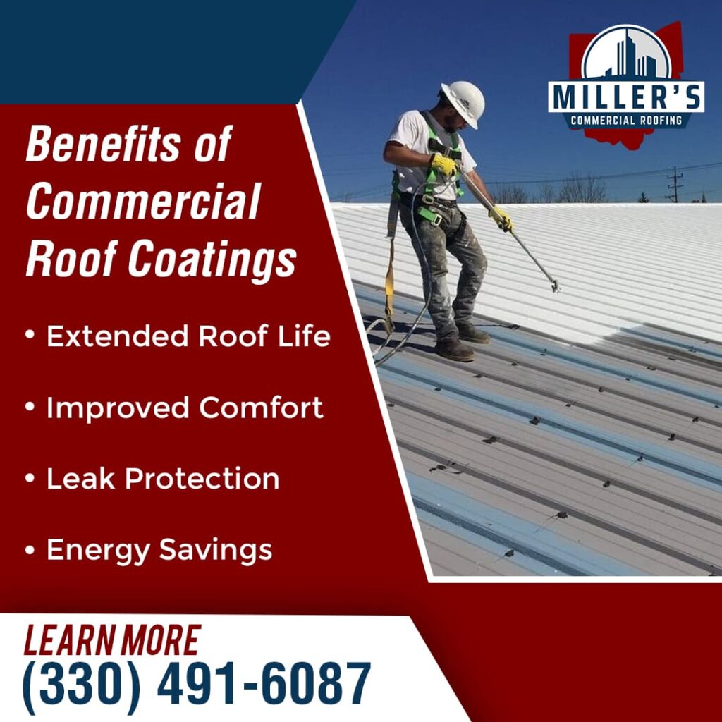 A roofer in safety harness and hard hat sprays a white coating onto a corrugated metal commercial roof under a bright blue sky.