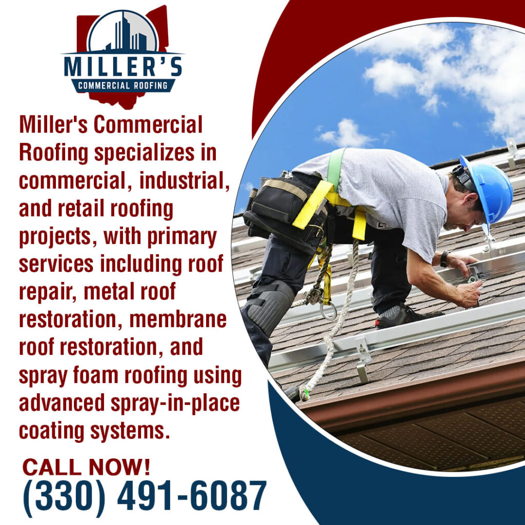 A roofer in a blue hard hat and safety harness works on a commercial roof with a blue sky and clouds in the background.